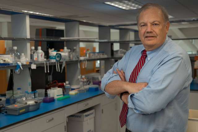 Dennis Slamon, MD, PhD standing in a lab with his arms crossed