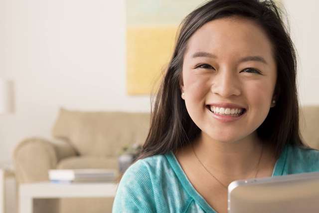 Smiling young woman seated on couch