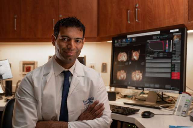Dr. Amar U. Kishan sitting in front of a computer monitor