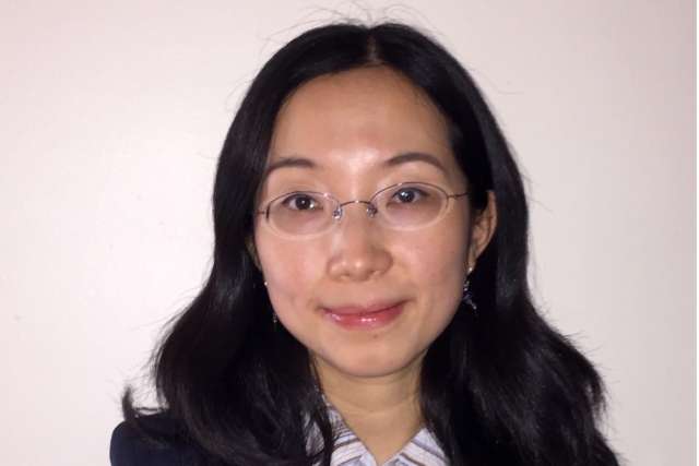Anjie Zhen, PhD, headshot: woman with glasses in navy blazer