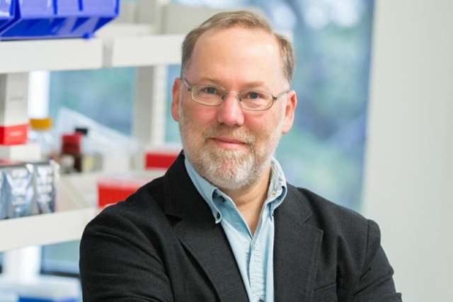 Fred Ramsdell in light blue shirt and dark jacket in laboratory