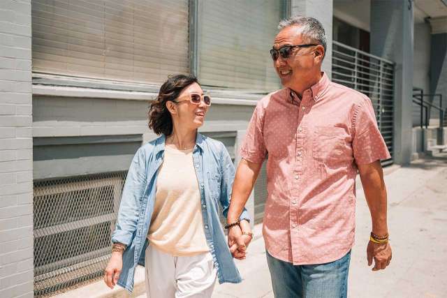 Older couple walking together holding hands