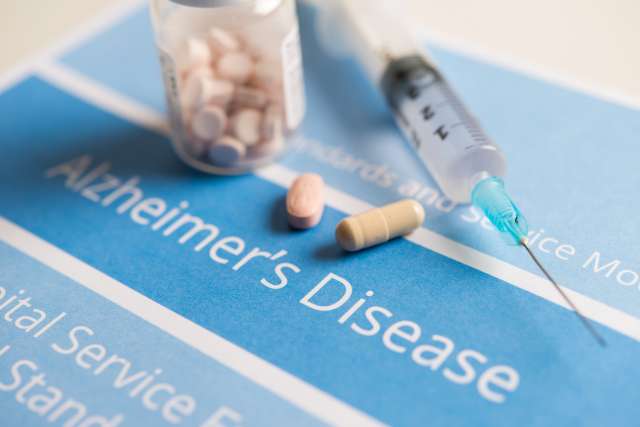 Medication sits on top of a pamphlet about Alzheimer's disease.