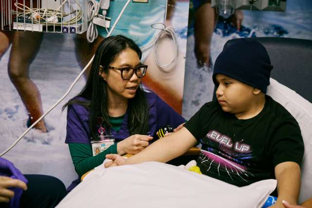 A Chase Child Life Specialist cares for a young boy.