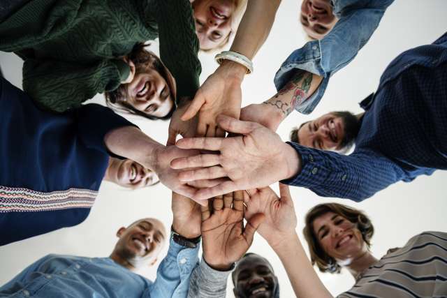 Group of cancer patients holding hands in a circle