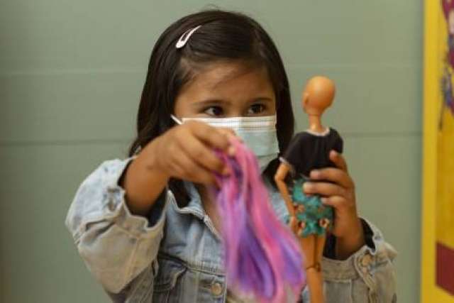Patient Layla Lopez adding long pink and purple hair to Brave Barbie.