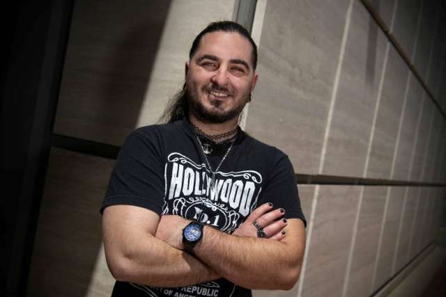 Darius Ardalan posing for picture standing next to a wall with arms crossed