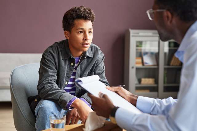 Young adult speaking to a doctor at the AYA Cancer Center Simms Mann