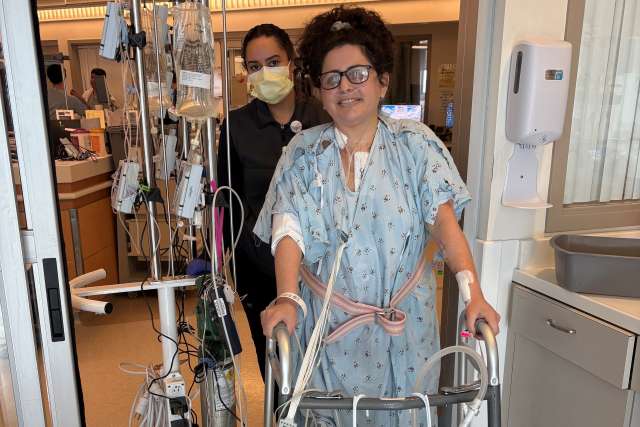 A patient walks through a hospital using a walker.