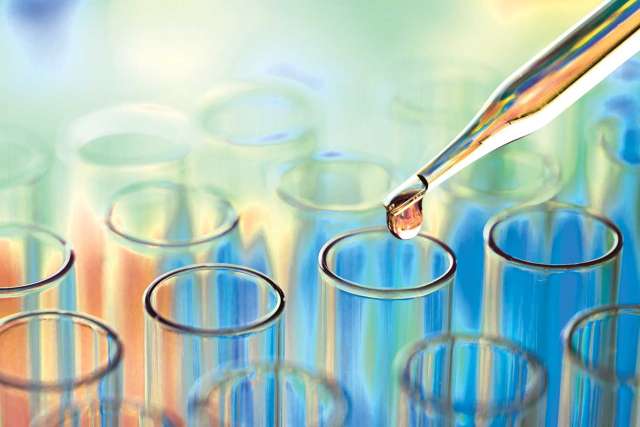 Colorful light refracting on test tube rack and dropper