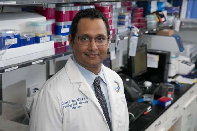 Dr. Dinesh Rao in white lab coat in his laboratory