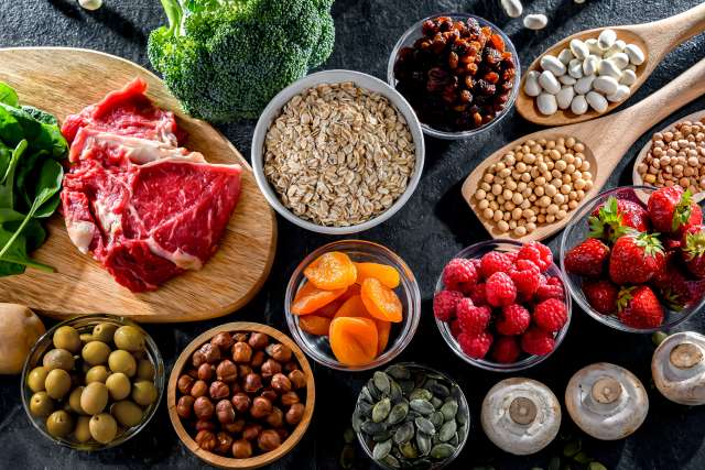A table with fruit, nuts, vegetables and meat.