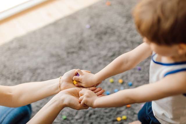 An adult and child practice motor skills.