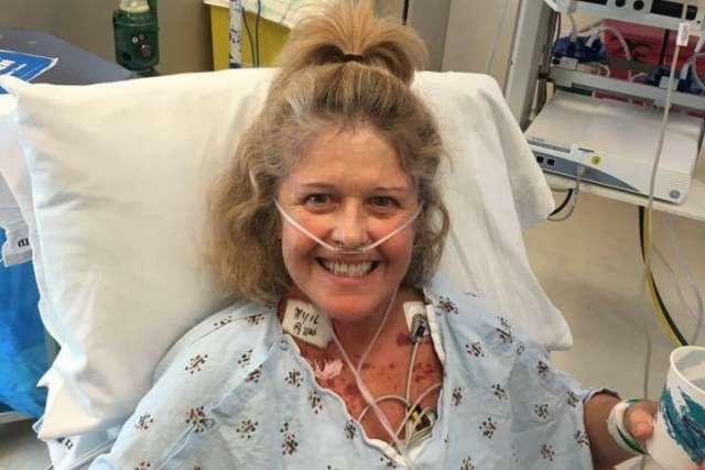 Smiling woman in hospital bed with nasal cannula