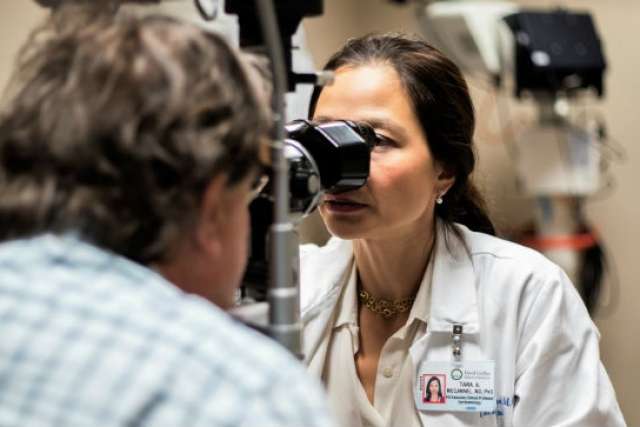 Dr. Tara McCannel performing an eye exam with a slit lamp on a patient