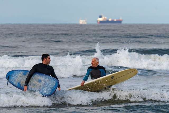 two men in the ocean on surfboards 