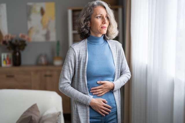 Older woman holding abdomen in pain
