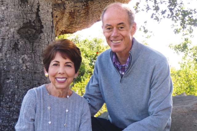 Connie Frank and Evan Thompson smiling outside.