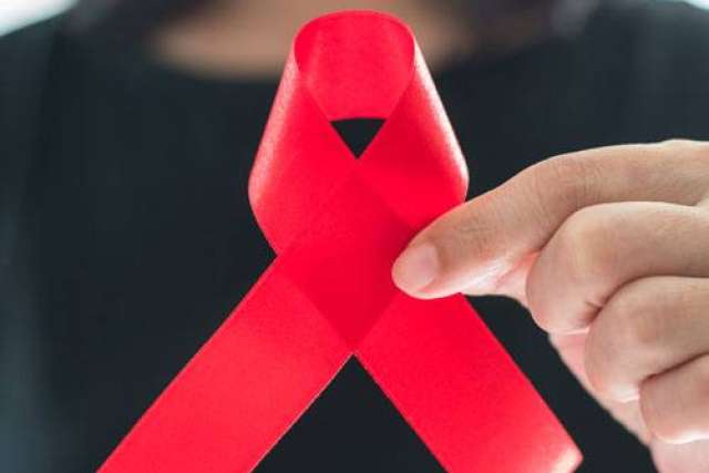 Woman holding a red AIDS awareness ribbon