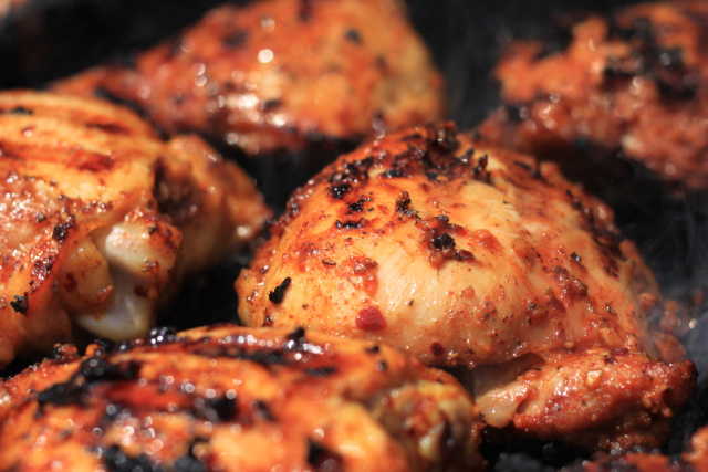 Grilled chicken pieces with char marks and glossy glaze