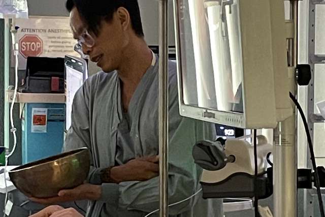 Nurse anesthetist Huy Vo plays a Tibetan singing bowl for a patient preparing to undergo anesthesia at Ronald Reagan UCLA Medical Center.