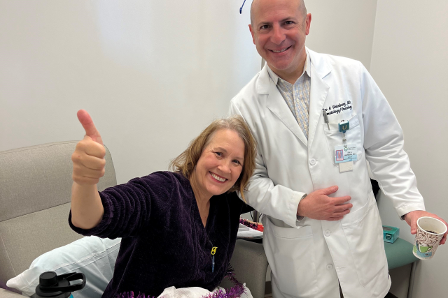 A happy patient with her doctor in a hospital room.