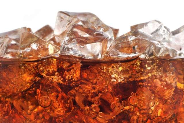 Fizzy dark beverage with ice cubes at the top.