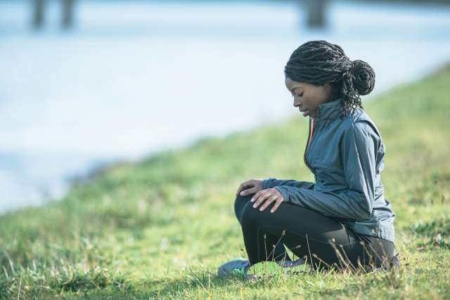 A woman meditates at a park