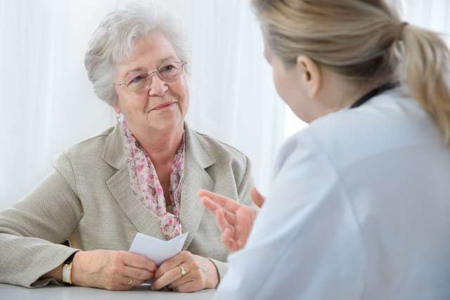 Doctor talking with a breast cancer patient in the exam room