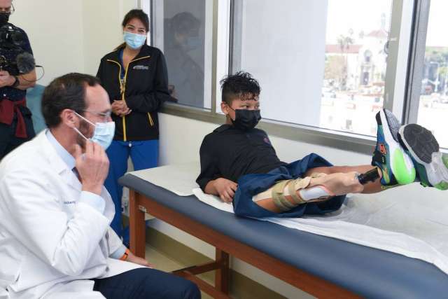 Doctor Anthony Scaduto examining 10-year-old Efrain Ordoñez Jr's new prosthetic leg
