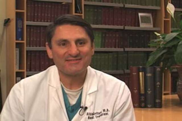 Dr. Albin Gritsch in white coat in office with bookshelves