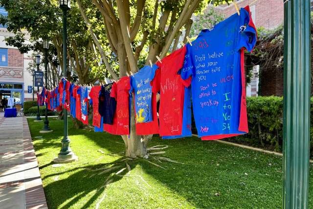 Red and blue T-shirts strung on a line along an outdoor walkway