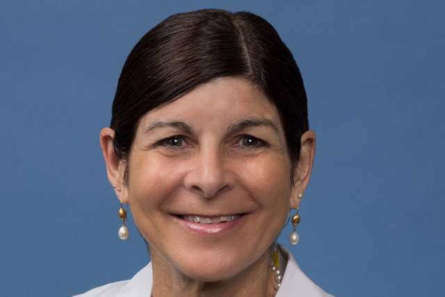 Holly R. Middlekauff, MD headshot wearing white lab coat and pearl earrings