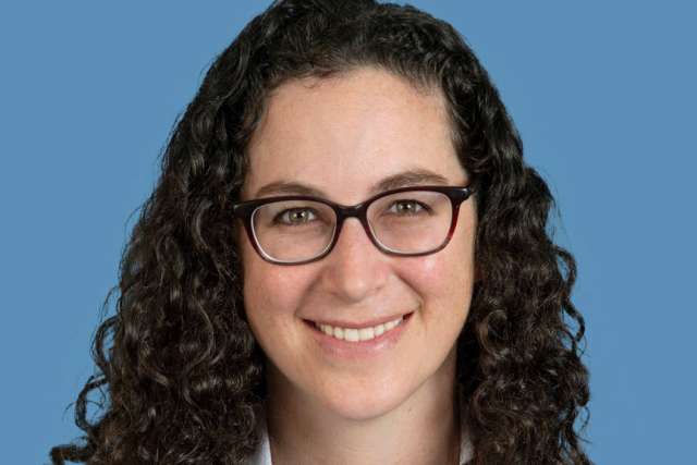 Ashley F. Stein-Merlob, MD wearing a white coat and glasses, smiling