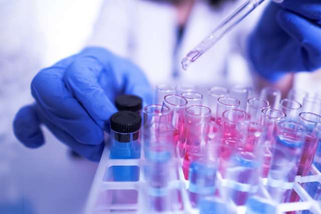 Lab worker testing samples in test tubes