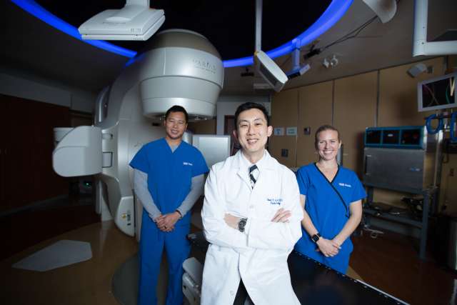 Dr. Robert Chin in Radiation Oncology in front of a treatment machine. 