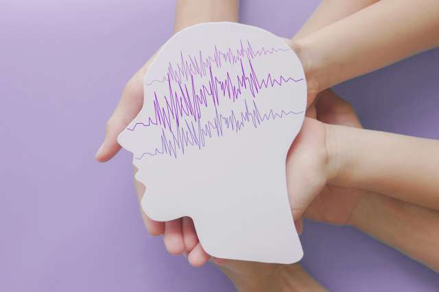 Hands holding up head silhouette filled with frequency lines