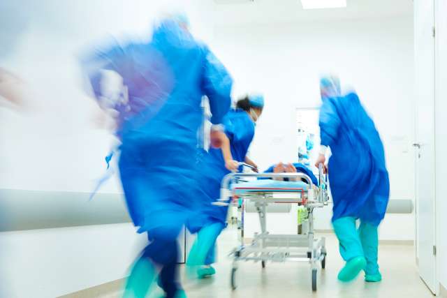 ER staff with gurney rushing patient to ER