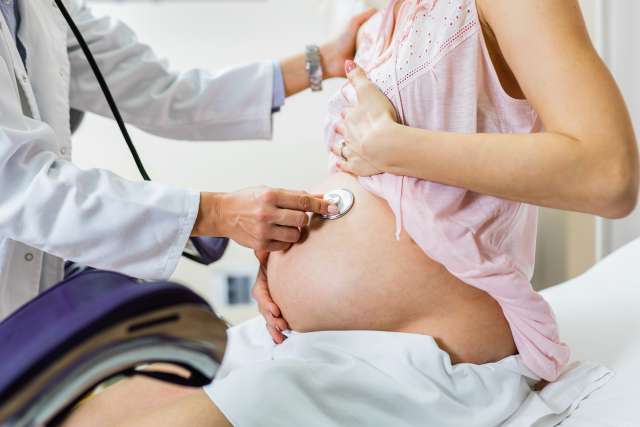 Gynecology examination and consultation. Pregnant woman with her doctor at clinic.