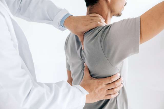 Physiotherapist doing healing treatment on man's back.Back pain patient, treatment, medical doctor, massage therapist.