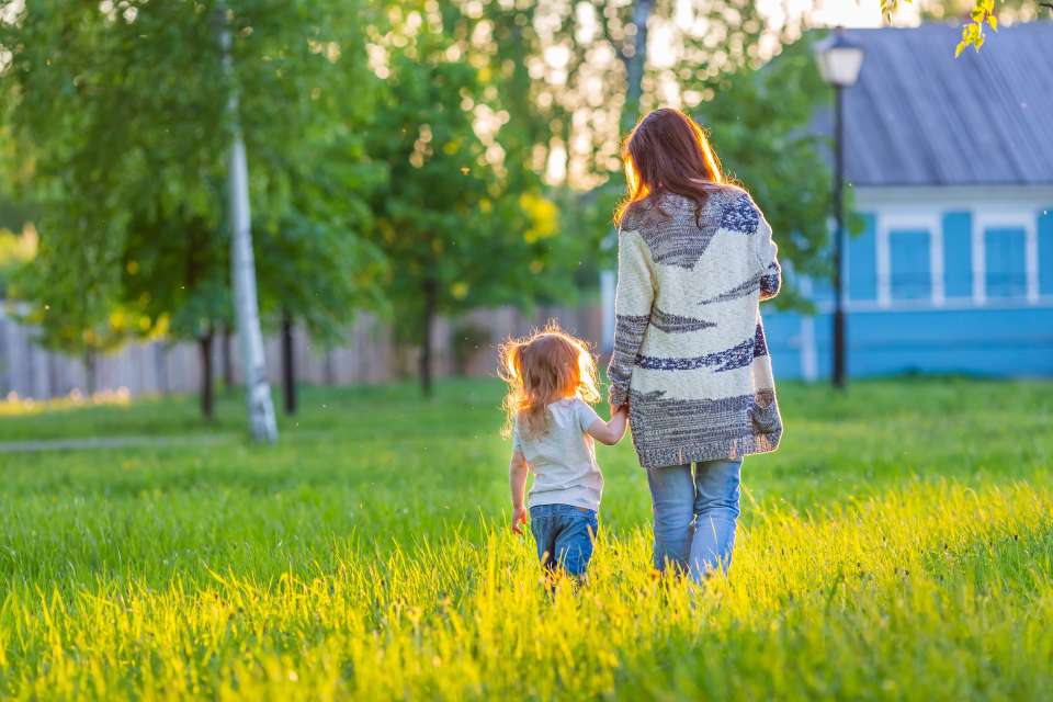 Mother and daughter holding hands and walking