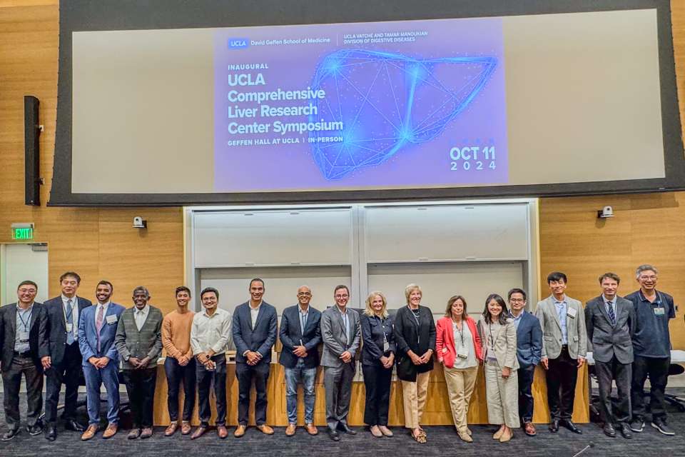 Group photo of conference participants in front of a presentation screen.