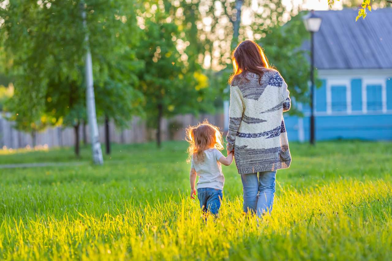 Mother and daughter holding hands and walking