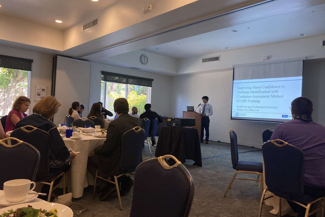 A MSTAR student presenting in a conference hall with an audience