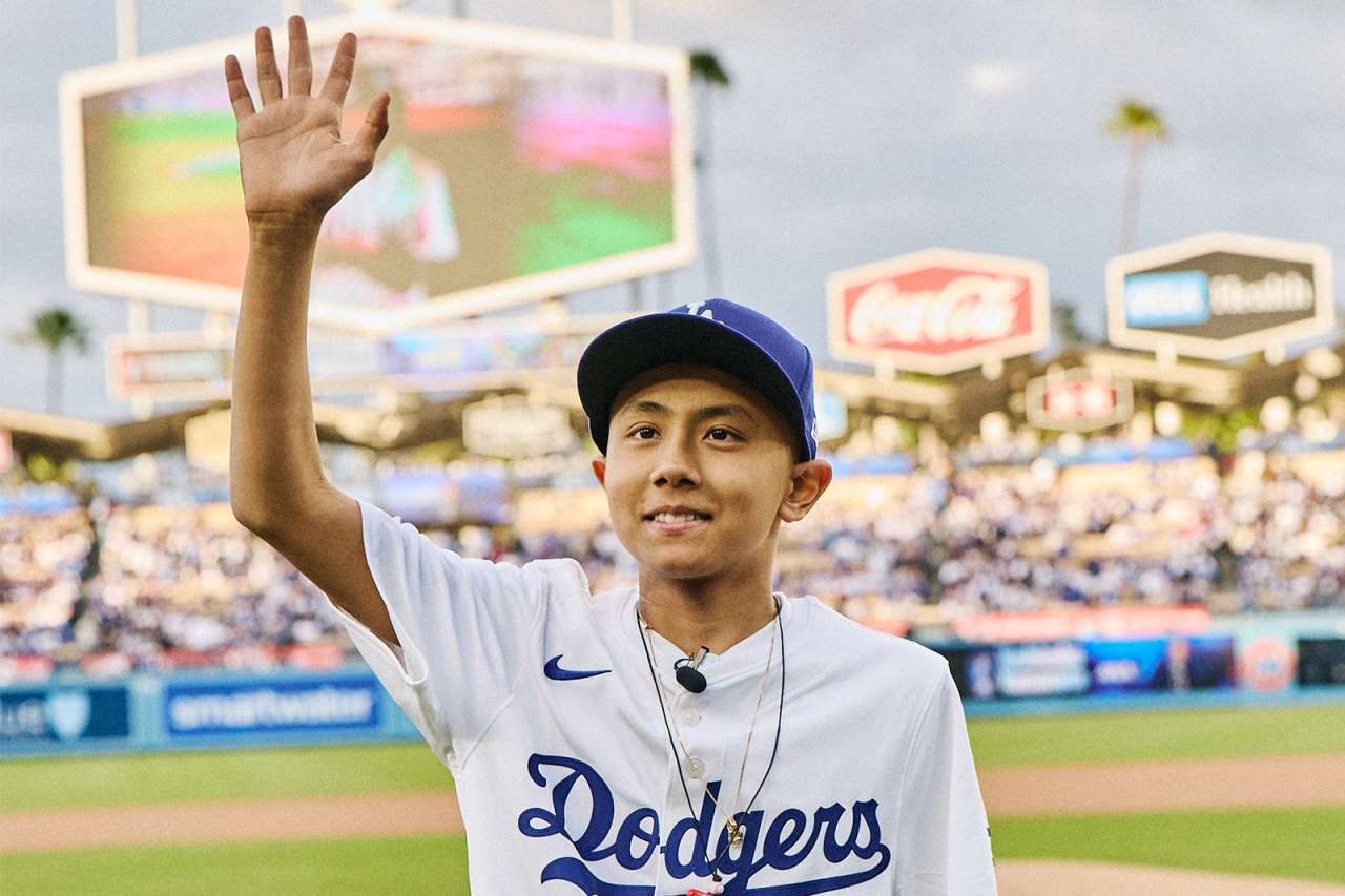 A teen oncology patient waves to the fans from the Dodger Stadium field.