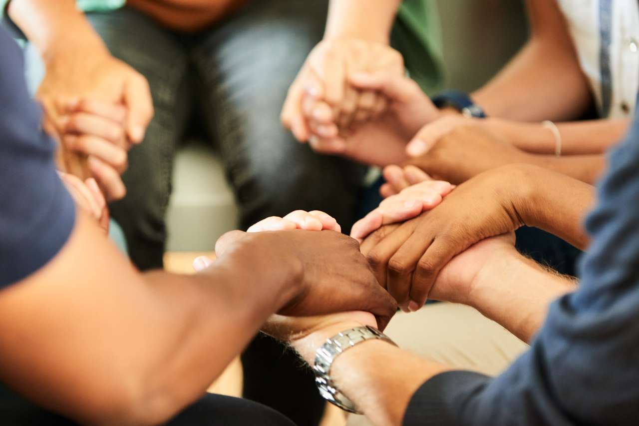 Group of men in a support group in a circle and holding hands