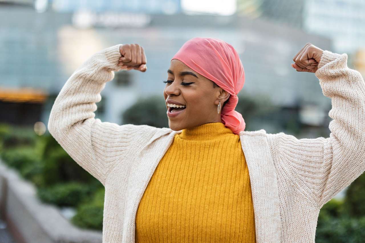 woman with headscarf flexing arms