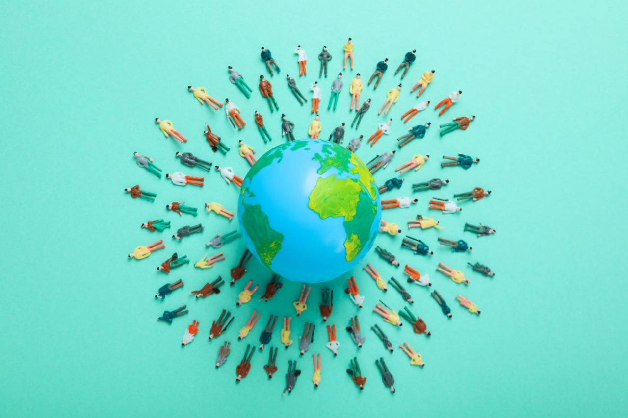 A globe surrounded by many small figures, possibly representing world population.