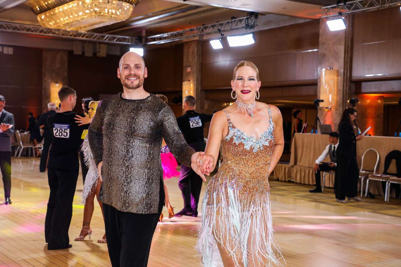 A man and woman participate in a ballroom dance competition.