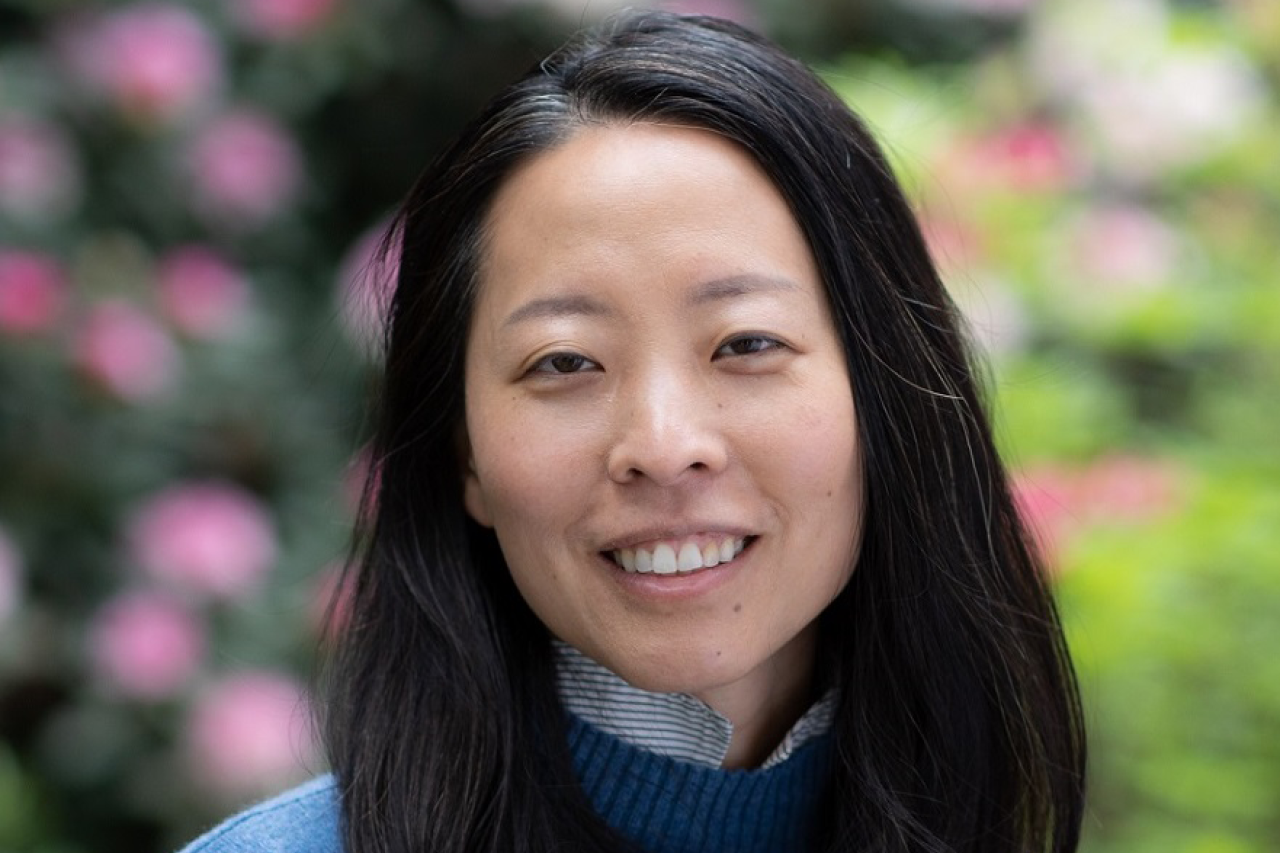 Headshot for Susan Wong in front of a garden with pink flowers